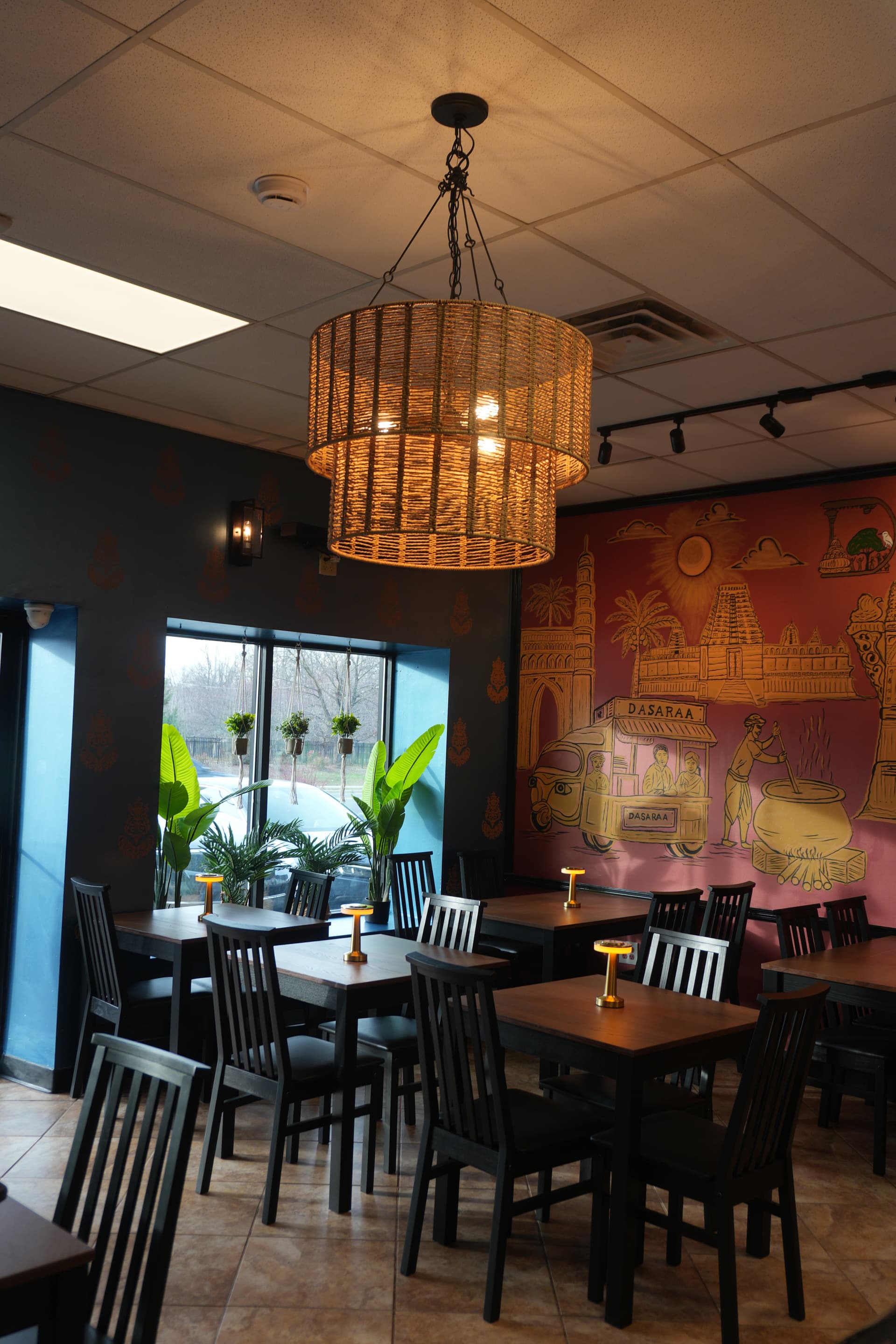 Dasaraa restaurant dining area with chandelier and mural