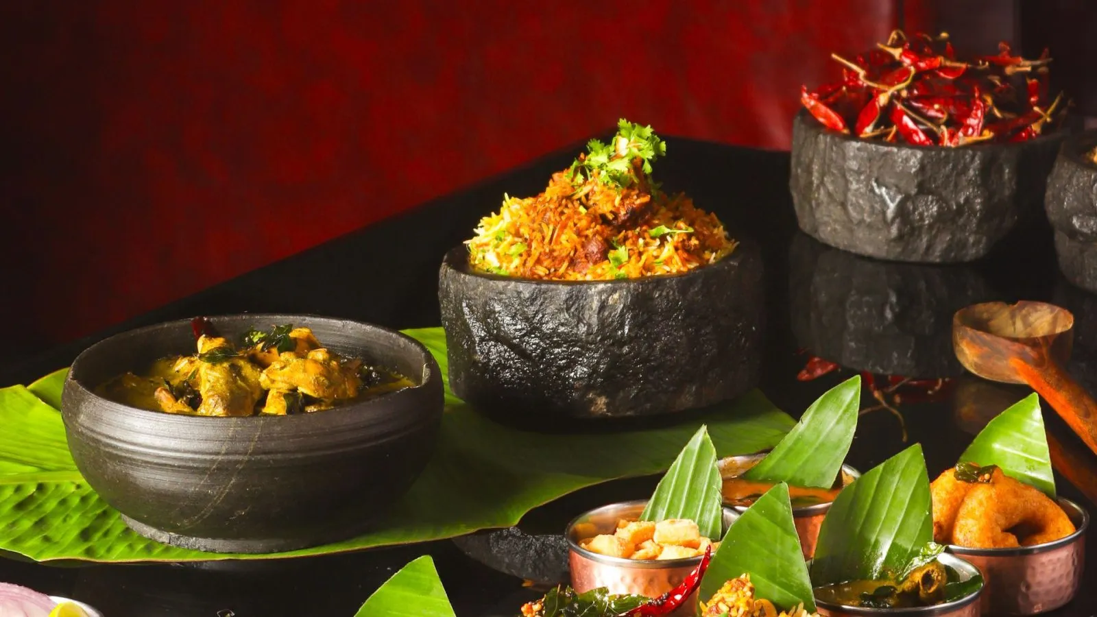 Biryani and curry spread with banana leaves