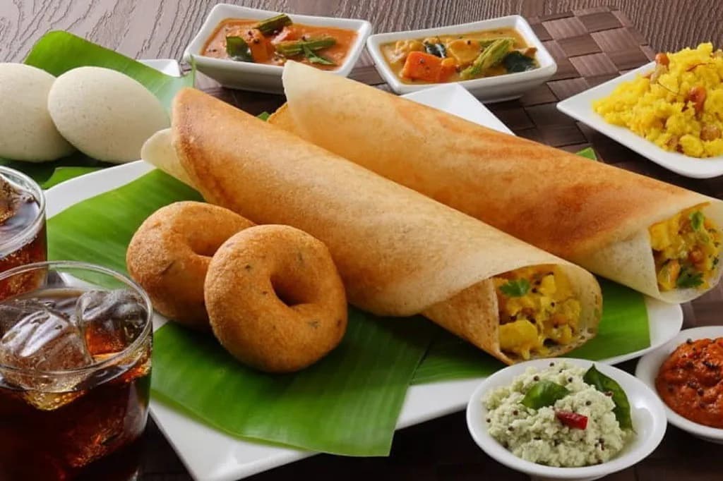 Dosa platter with vada, idli, sambar, and chutneys